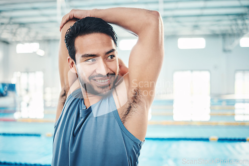 Image of Happy, man and stretching at a swimming pool for training, cardio and exercise, indoor and flexible. Athlete, smile and swimmer stretch for workout, swim and fitness routine, warm up and preparation