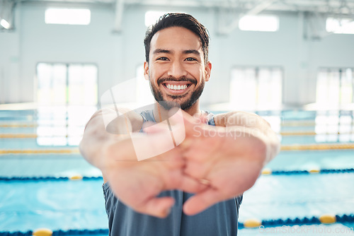 Image of Portrait, stretching and man at swimming pool for training, cardio and exercise, indoor and flexible. Face, smile and swimmer stretch before workout, swim and fitness routine, warm up and preparation