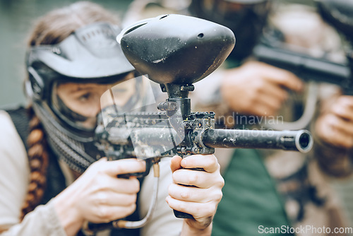 Image of Paintball, sports and woman aim with gun for shooting ready for games, arena match and battlefield in woods. Adrenaline exercise, adventure and girl with weapon in camouflage, action and safety gear