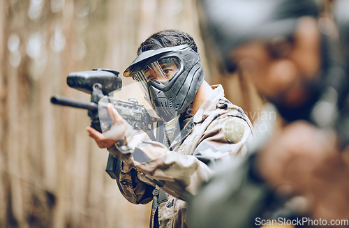 Image of Paintball, gun and target with man, sports and action outdoor, battlefield and soldier, focus during war game. Extreme sport, aim weapon and military mission, exercise and fitness with team