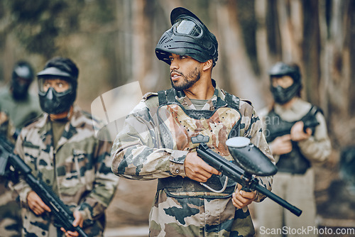 Image of Paintball, sports and team with gun in woods ready for games, arena match and shooting battle outdoors. Adrenaline, adventure and people with weapons in camouflage, military clothes and action gear