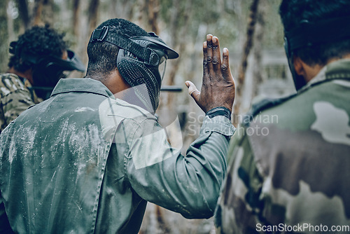 Image of Hand sign, stop and men in training, paintball and planning, strategy and plan of action outdoor. Military, men and hands by guy leading team in sports, shooting and intense target practice together