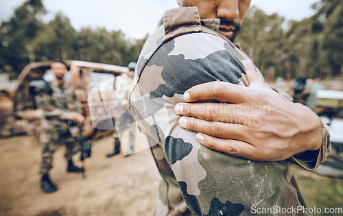 Image of Injury, paintball and arm pain by man on field for team sport, fitness or training outdoor. Shoulder, problem and hands of guy with issue, arthritis or accident during exercise, match and performance