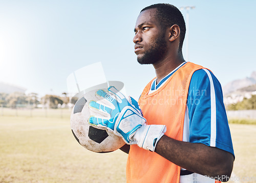 Image of Black man, football and goalkeeper training on field for focus, exercise or gloves for safety in sunshine. Athlete, soccer goalie and hands with ball, vision or mindset for workout, strategy or sport