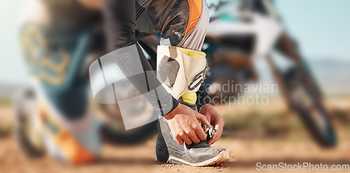 Image of Start, motorcycle and man tying laces in nature for adventure, holiday and race in the countryside. Road, travel and biker ready with shoes for a journey on a motorbike on a dirt road for freedom