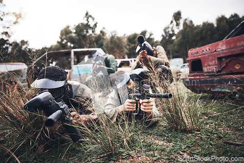 Image of Paintball, team and camouflage waiting in grass for sneak attack, aim or practice with guns. Group of soldiers in extreme sports, teamwork or coordination in hiding for strategic plan to win match