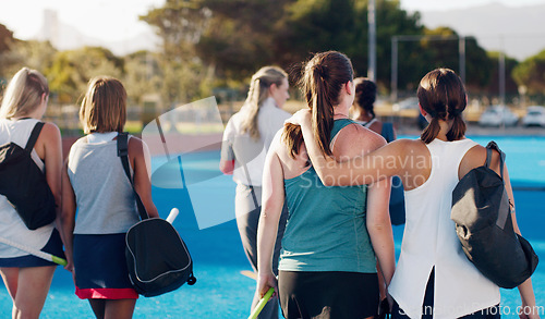 Image of Women, hockey and teamwork on field together with support, solidarity or walking to fitness training with coach. Sports group, friends and walk from workout, outdoor exercise or hug with conversation