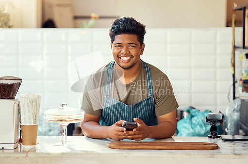 Image of Barista portrait, cafe black man on a phone for happy online sales, small business management or ecommerce. Smile waiter, cashier or worker person on smartphone, technology or service in restaurant