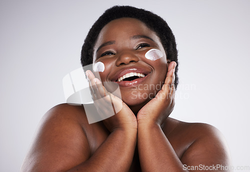 Image of Thinking, skincare and cream with a model black woman in studio on a gray background for plus size beauty. Idea, skin and lotion with an attractive young female touching her face after treatment