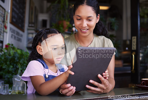 Image of Digital tablet, coffee shop and mother with her child reading the online menu before ordering. Technology, internet and mom on a date with her girl kid with a touchscreen mobile device in a cafe.