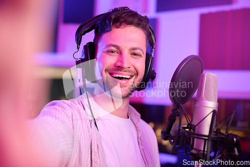 Image of Musician in recording studio, selfie and portrait with smile, making music with microphone and headphones. Social media content, happy in picture and audio, podcast or radio dj with man face