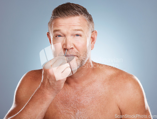 Image of Skincare, nose tweezers and portrait of man on blue background for wellness, healthy skin and facial hair. Beauty, cleaning and face of male with tool for grooming, self care and hygiene in studio