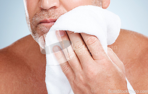 Image of Closeup, old man and towel to dry face, clean and hygiene for healthy skin, beard and guy on grey studio background. Zoom, senior citizen and mature male with cosmetics cloth, washing and skincare