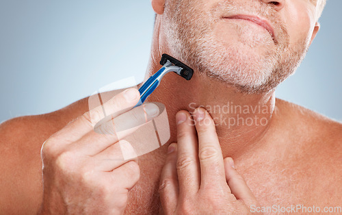 Image of Grooming, razor and man shaving his beard in a studio for a facial, skincare and epilation routine. Health, wellness and mature male doing face hair removal treatment for self care by gray background