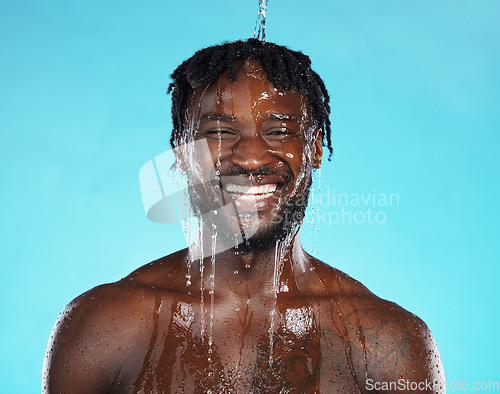 Image of Shower, portrait and black man isolated on blue background with water drops for face cleaning, body and skincare glow. Strong, beauty and happy model or person in studio headshot washing for hygiene