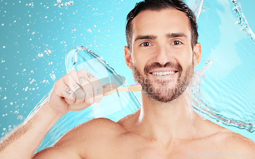 Image of Eco friendly toothbrush, water and portrait of man on blue background for wellness, hygiene and brushing teeth. Cleaning, dental and face of male with toothpaste for grooming, whitening and health