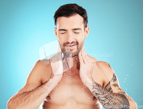 Image of Skincare, man washing face and water, morning cleaning treatment isolated on blue background. Facial hygiene, splash and male model grooming for health, wellness and clean skin care beauty in studio.