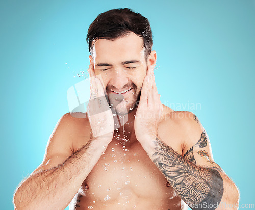 Image of Water, skincare and man with cleaning beard, morning beauty treatment isolated on blue background. Facial hygiene, splash and male model grooming face for health, wellness and spa skin care in studio