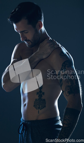 Image of Fitness, studio and man with tattoo, muscle and strong body for wellness, exercise and training. Motivation, sexy model and body of male athlete on dark background for workout, power and bodybuilder