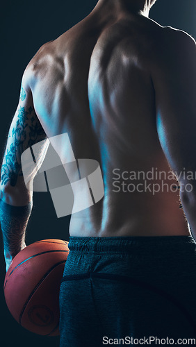 Image of Sports, body and back of man with ball on black background, isolated with neon blue light and basketball. Fitness, muscle and topless male model in artistic dark studio for workout and gym aesthetic.