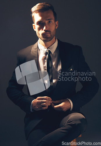 Image of Businessman, suit and portrait in dark studio for corporate fashion, design or professional aesthetic. Young executive leader, model and focus for vision, entrepreneur mindset or tattoo by background