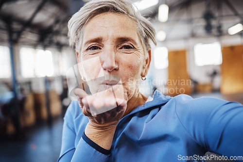 Image of Senior woman, blowing kiss and fitness selfie at gym while happy after exercise, training or workout. Portrait of old person with smile for health, wellness and motivation for healthy lifestyle goals