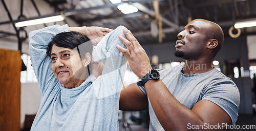 Image of Coach, personal trainer and senior woman stretching arms in gym with black man for flexibility. Physiotherapy, training and elderly female with trainer helping with workout and exercise for health.