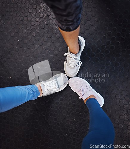 Image of Women, gym and shoes on floor in circle for teamwork, motivation and support for fitness training. Woman exercise group, sneakers and huddle for team building, solidarity and workout in top view