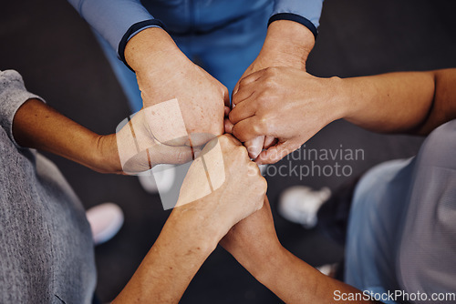 Image of Hands, teamwork and exercise with sports people standing in a huddle at gym from above for health. Collaboration, support and motivation with a man and woman athlete group in a circle for fitness