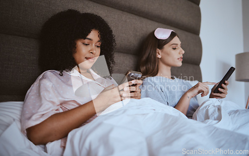 Image of Friends, sleepover and phone with women in bed for communication, internet and contact. Happy, relax and connection with girl lying in bedroom with technology, digital streaming and social media