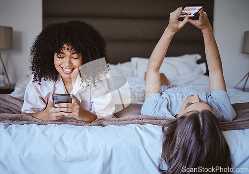 Image of Video call, phone and friends with women at sleepover for communication, internet and contact. Happy, relax and smile with girl lying in bedroom with technology, digital and social media together