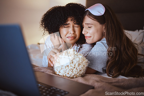 Image of Laptop, movie and horror with friends and popcorn in bedroom for sleepover, bonding and streaming. Technology, internet and relax with scared women at night for cinema, subscription and entertainment