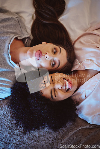 Image of Comic friends, bed and face of women happy about a sleepover, quality time and fun in pajamas. Gen z people excited and funny in a bedroom with diversity, motivation and happiness in a bedroom