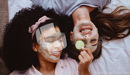 Image of Facial, cucumber or beauty with girl best friends lying on the floor together for treatment at a sleepover. Face mask, skincare or natural care with a female and friend at home to relax while bonding