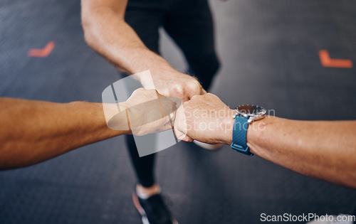 Image of Group fist bump, hands and gym for motivation with personal trainer for health, wellness or training with smartwatch. Team, workout or exercise for fitness goal, muscle development or body healthcare