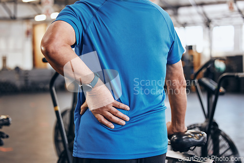 Image of Sports, gym and old man with hand on back pain, emergency during workout at fitness studio. Health, wellness and inflammation, zoom on senior person hands on muscle cramps while training or exercise.