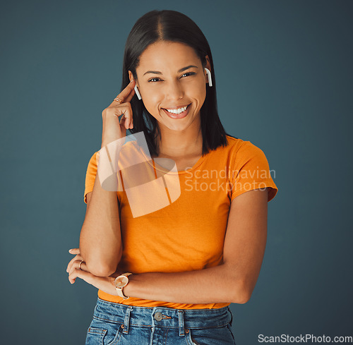 Image of Woman, portrait and listening to music online while happy on a studio background. Smile on face of a young gen z person with earphones for podcast, radio or audio sound to relax while streaming