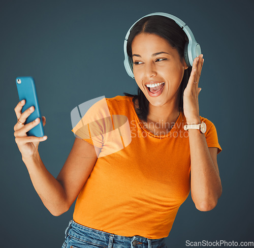 Image of Selfie, headphones and streaming podcast or music on phone or mobile app isolated against a studio background. Fun, sound and female enjoying and listening to radio or audio smiling and happy