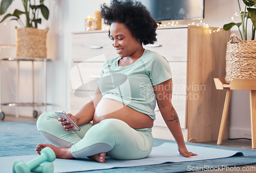 Image of Yoga, pregnant and black woman with phone in home for social media and texting on workout break. Pregnancy, zen pilates and female with mobile smartphone for web browsing or scrolling after training.