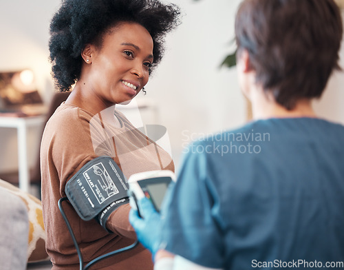 Image of Black woman, healthcare and blood pressure checkup with caregiver monitoring or checking pulse at home. Happy African American female patient or visit from medical nurse for health and wellness
