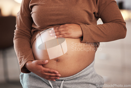 Image of Hands, stomach and pregnant black woman in home for maternity leave, health and wellness. Pregnancy, prenatal motherhood and female, mama or future mother touching belly with hope for newborn baby.