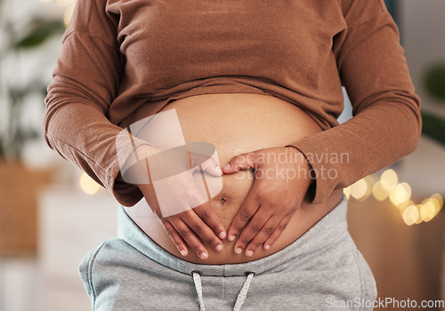 Image of Heart hands on belly, pregnant mother and closeup of happy black woman alone in Africa living room. Excited future parent, holding healthy abdomen at home and loving mommy in pregnancy care