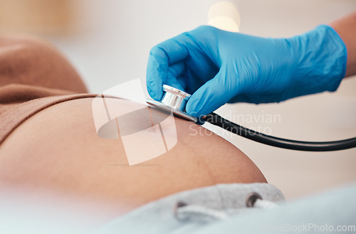 Image of Hand, stethoscope and the belly of a woman pregnant in a hospital for prenatal exam or checkup in the hospital. Healthcare, medical and pregancy with a doctor listening to the baby of a mother to be