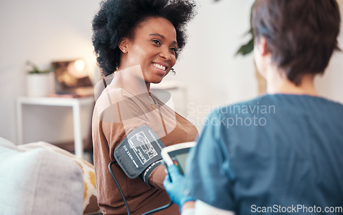 Image of Black woman, healthcare and checkup with caregiver in bedroom checking, blood pressure or pulse at home. Happy African American female patient or visit from medical nurse monitoring heart in wellness