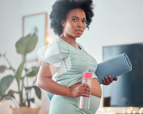 Image of Yoga, pregnant and portrait of black woman in home ready to start exercise, training or workout for health or fitness. Pregnancy, zen pilates and future mother with mat and water bottle for hydration