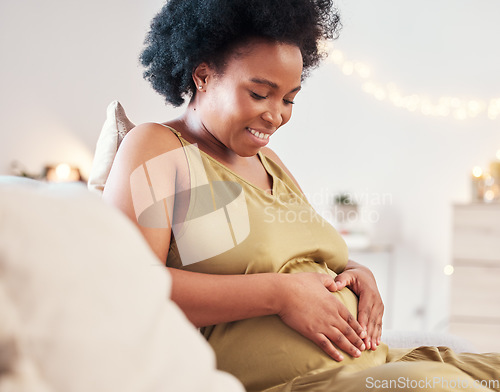 Image of Pregnant stomach, heart hand sign and happy black woman feeling mother hope and love. Mom care, sofa and living room lounge with a person holding abdomen happy about pregnancy and baby in a house