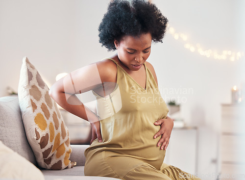 Image of Back pain, stomach and pregnant woman with healthcare stress, problem or risk on sofa in her living room. Backache, abdomen and pregnancy mother with medical emergency worry, labor or sick on couch