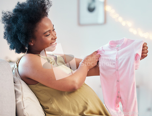 Image of Happy, check and pregnant woman with clothes for a baby, gift and happy with clothing for child. Mother, smile and African girl with fashion for a kid during pregnancy on the living room sofa