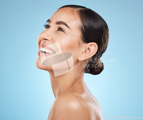 Image of Skincare, wellness and woman in studio with a healthy, natural and cosmetic face treatment. Beauty, cosmetics and happy female model from Brazil with makeup facial routine isolated by blue background