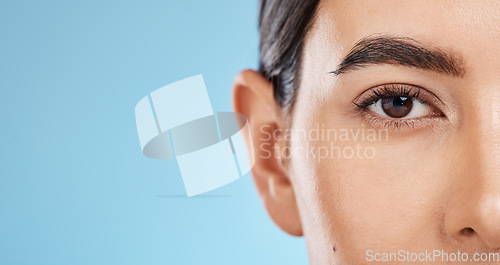 Image of Skincare, beauty portrait and eye wellness of a woman with mockup with makeup and cosmetics. Blue background, studio and isolated model face with microblading eyebrow and eyes health aesthetic